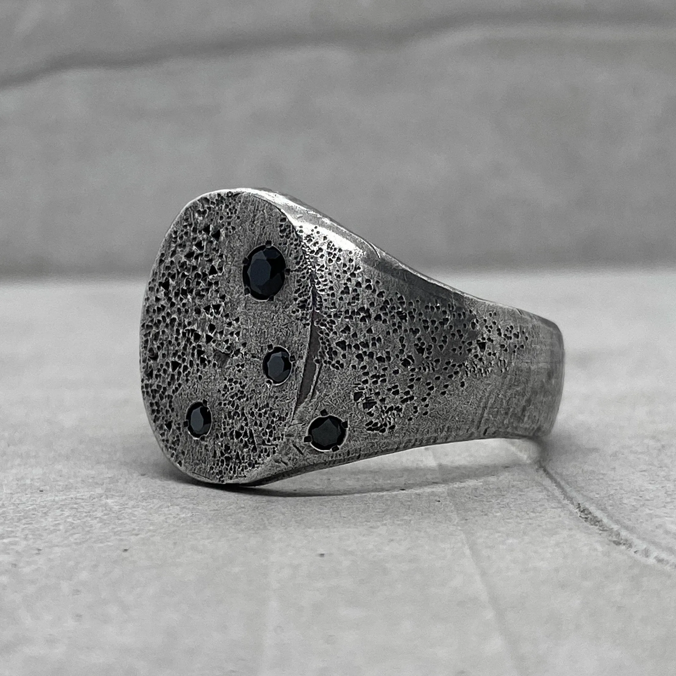 Space ring- textured oval signet ring with several black diamonds