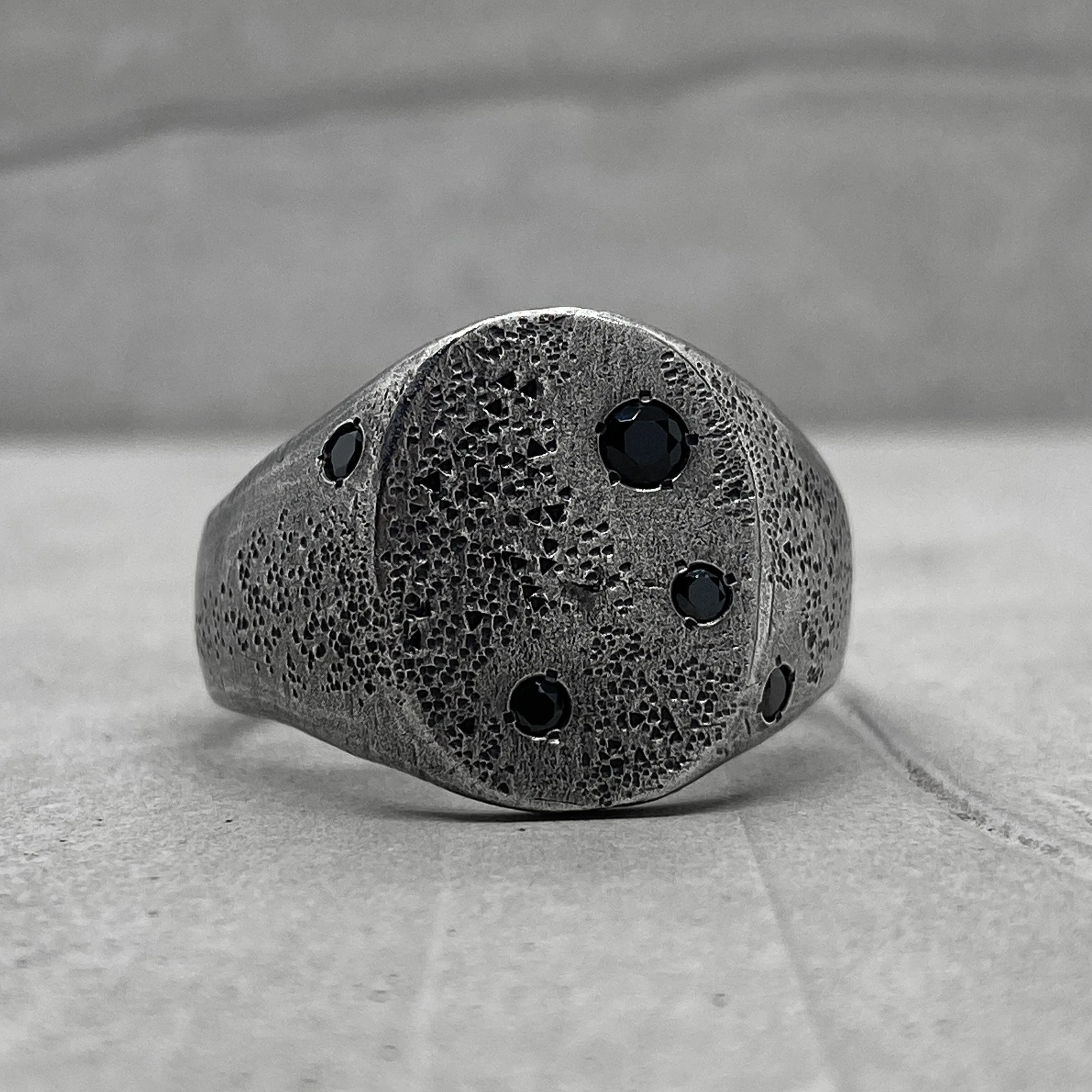Space ring- textured oval signet ring with several black diamonds