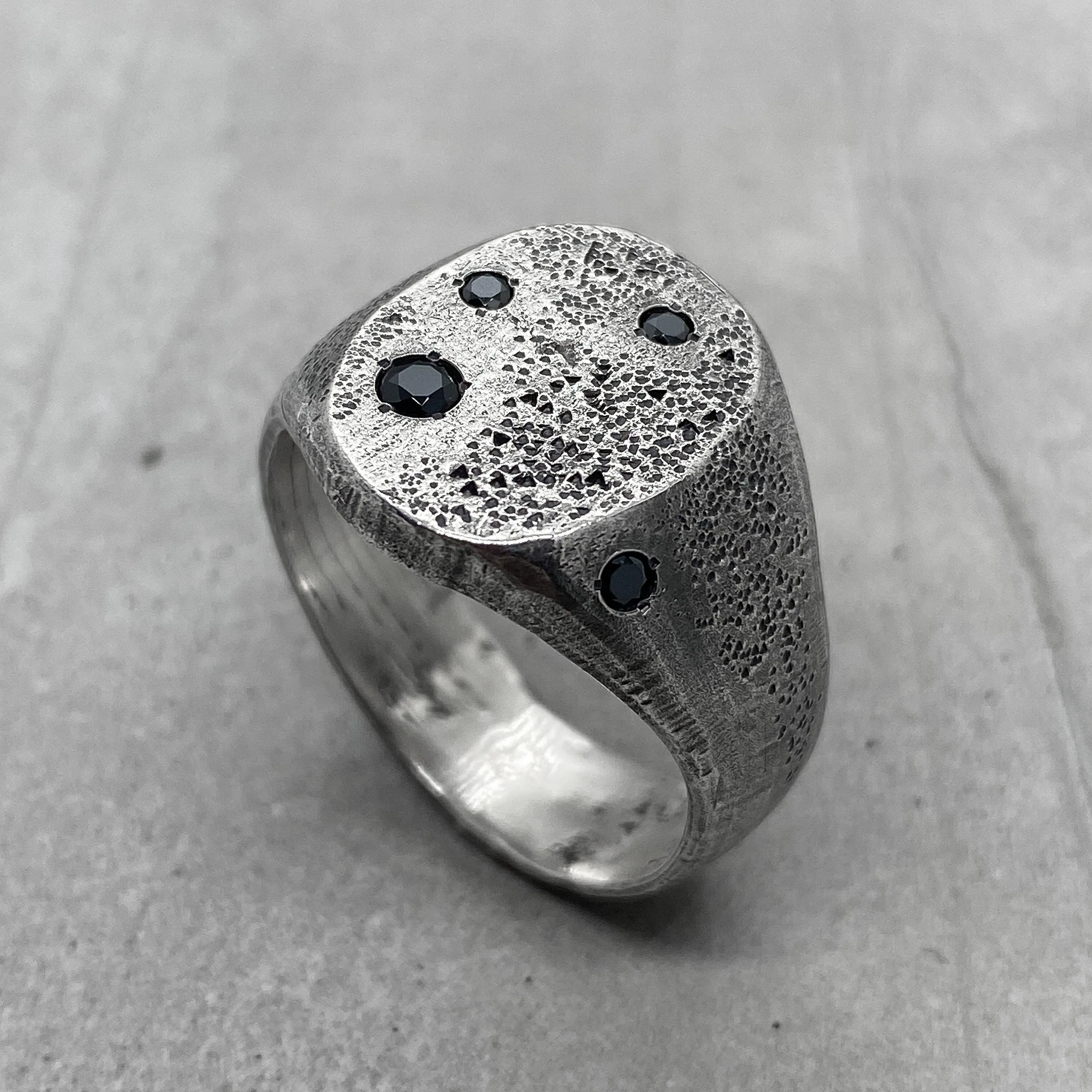 Space ring- textured oval signet ring with several black diamonds