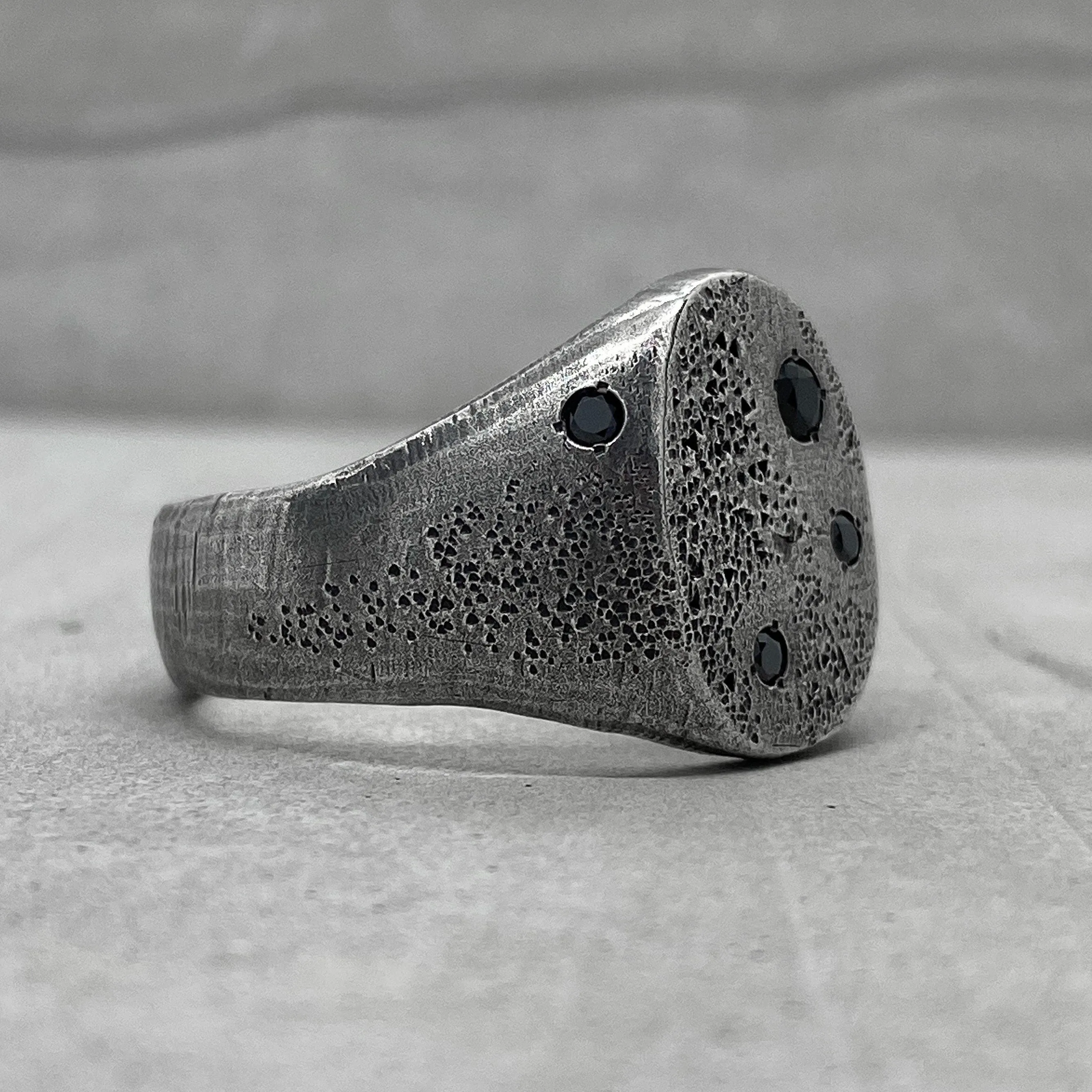 Space ring- textured oval signet ring with several black diamonds